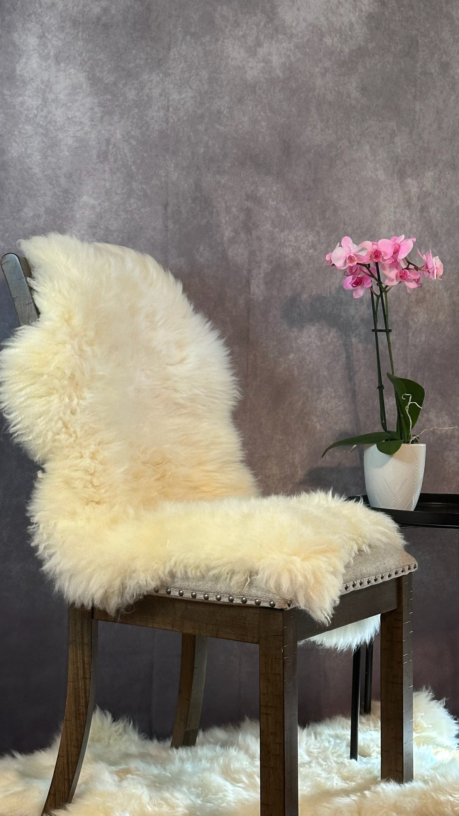Natural sheepskin rug styled over a chair for warm and inviting home decor
